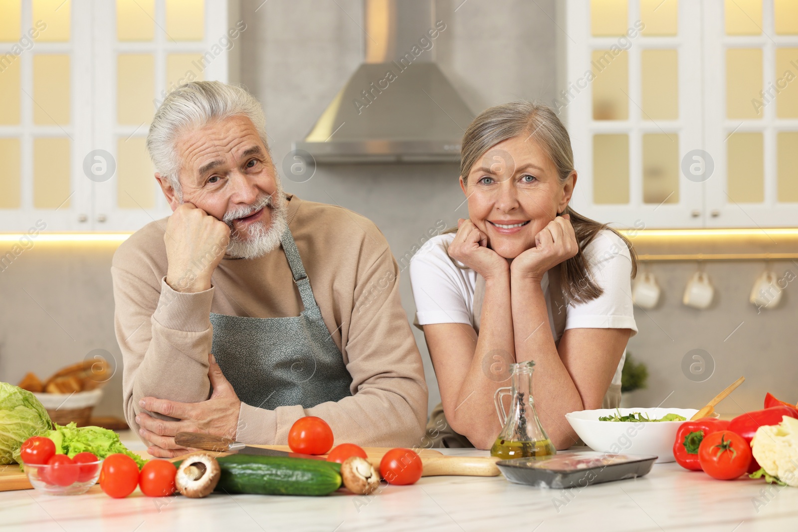 Photo of Happy senior couple at table in kitchen