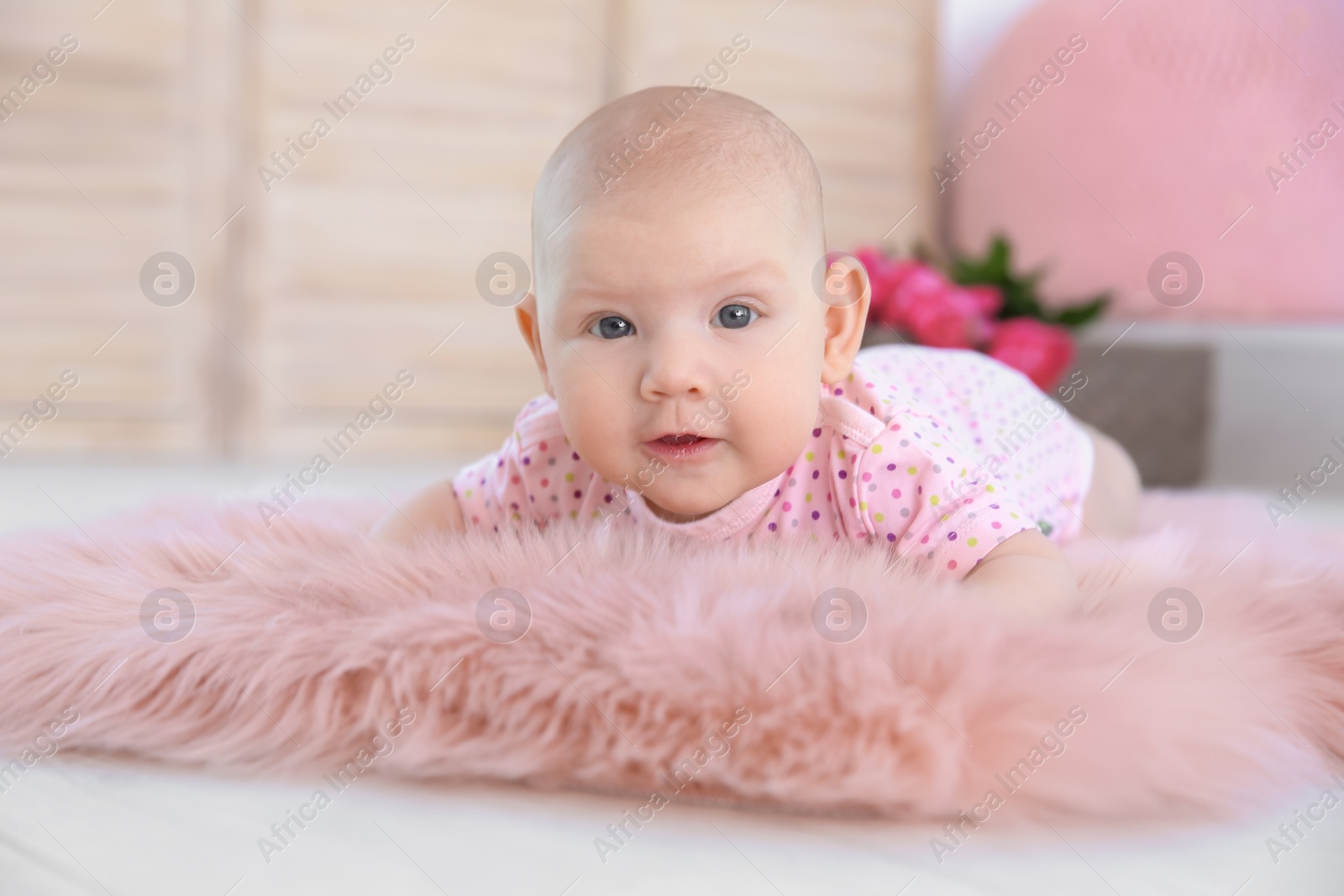 Photo of Adorable baby girl lying on fluffy rug