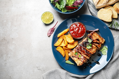 Delicious grilled ribs served on light grey table, flat lay. Space for text