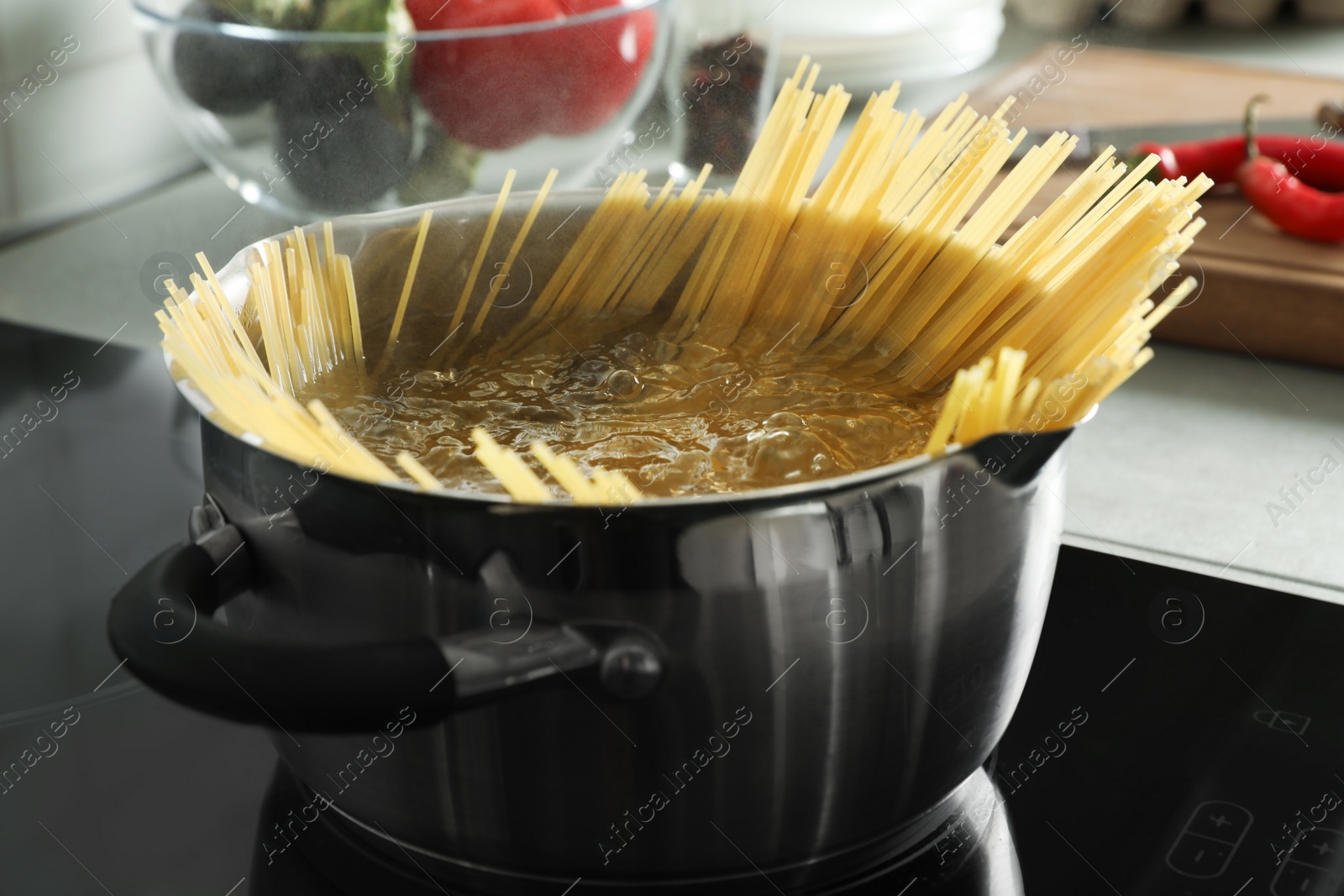 Photo of Cooking spaghetti in pot on electric stove