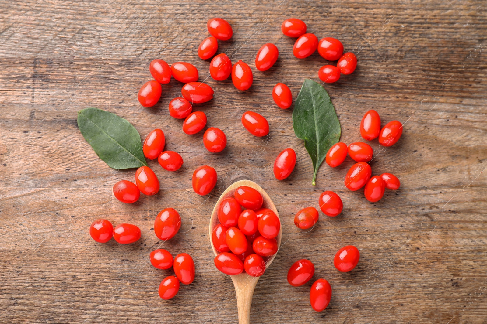 Photo of Fresh ripe goji berries on wooden table, flat lay