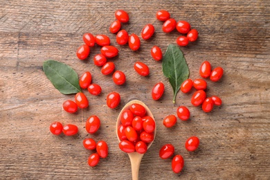 Photo of Fresh ripe goji berries on wooden table, flat lay