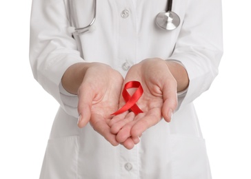 Photo of Doctor holding red ribbon on white background, closeup. AIDS awareness month