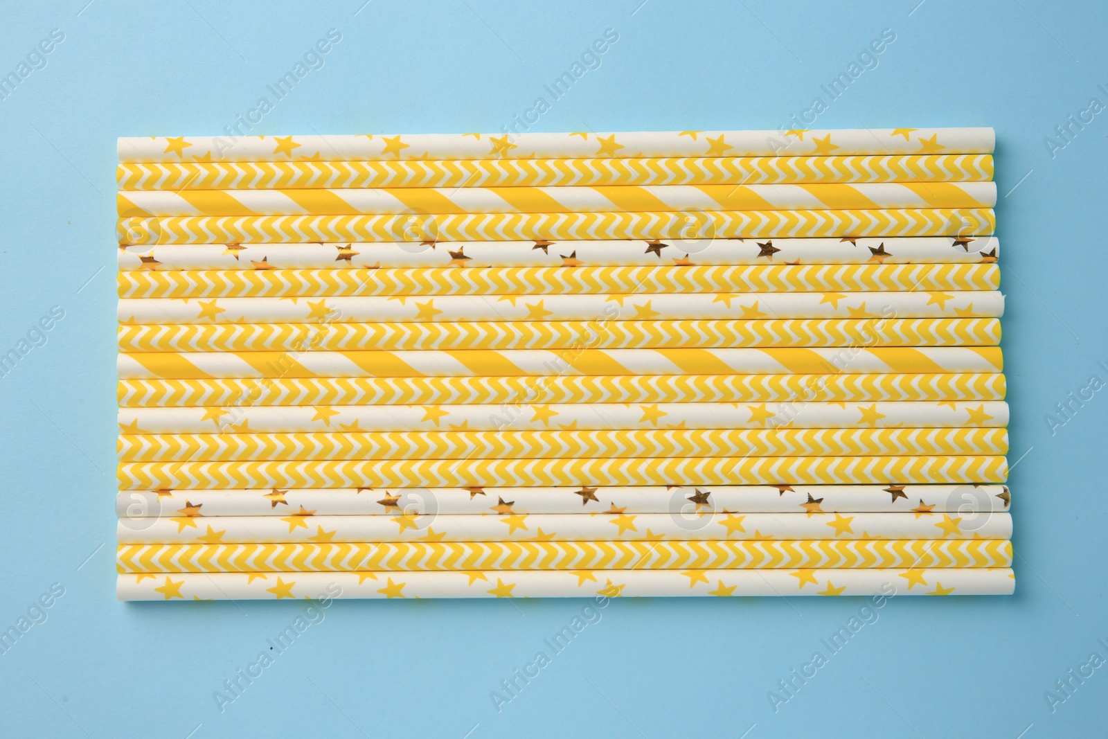 Photo of Many paper drinking straws on light blue background, flat lay