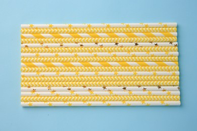 Photo of Many paper drinking straws on light blue background, flat lay