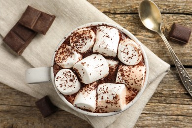 Delicious hot chocolate with marshmallows, cocoa powder and pieces on wooden table, flat lay