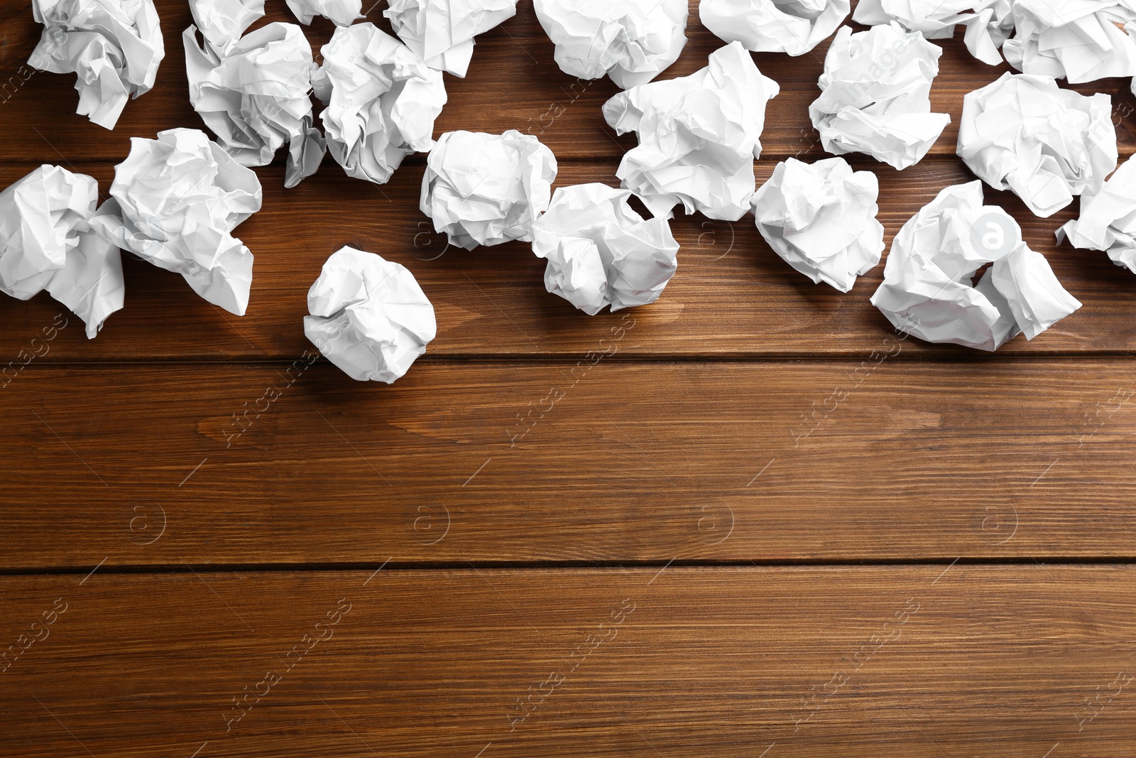 Photo of Crumpled sheets of paper on wooden background, flat lay. Space for text