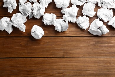 Crumpled sheets of paper on wooden background, flat lay. Space for text