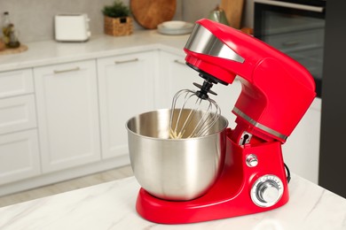 Photo of Modern red stand mixer on white marble table in kitchen, space for text