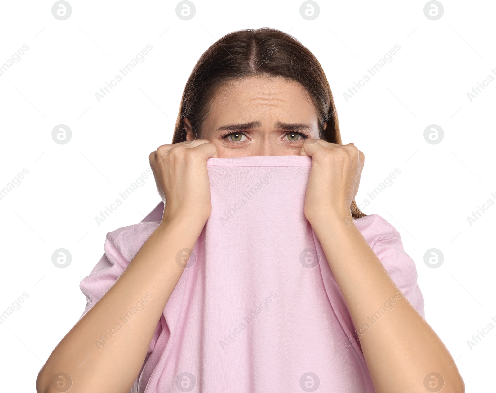 Photo of Embarrassed young woman covering face with shirt on white background