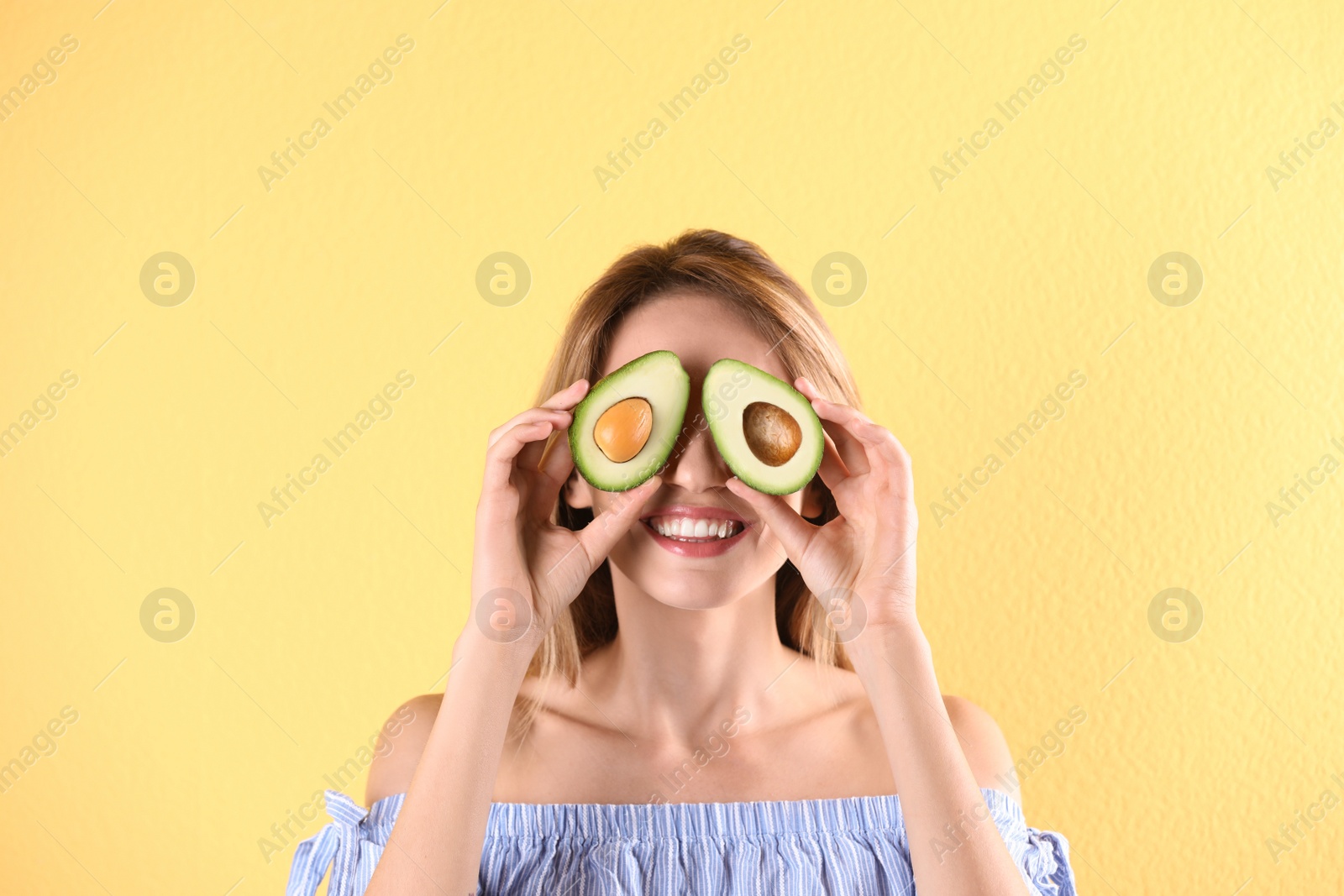 Photo of Portrait of young beautiful woman with ripe delicious avocado on color background