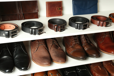 Photo of White shelving unit with different leather shoes and accessories