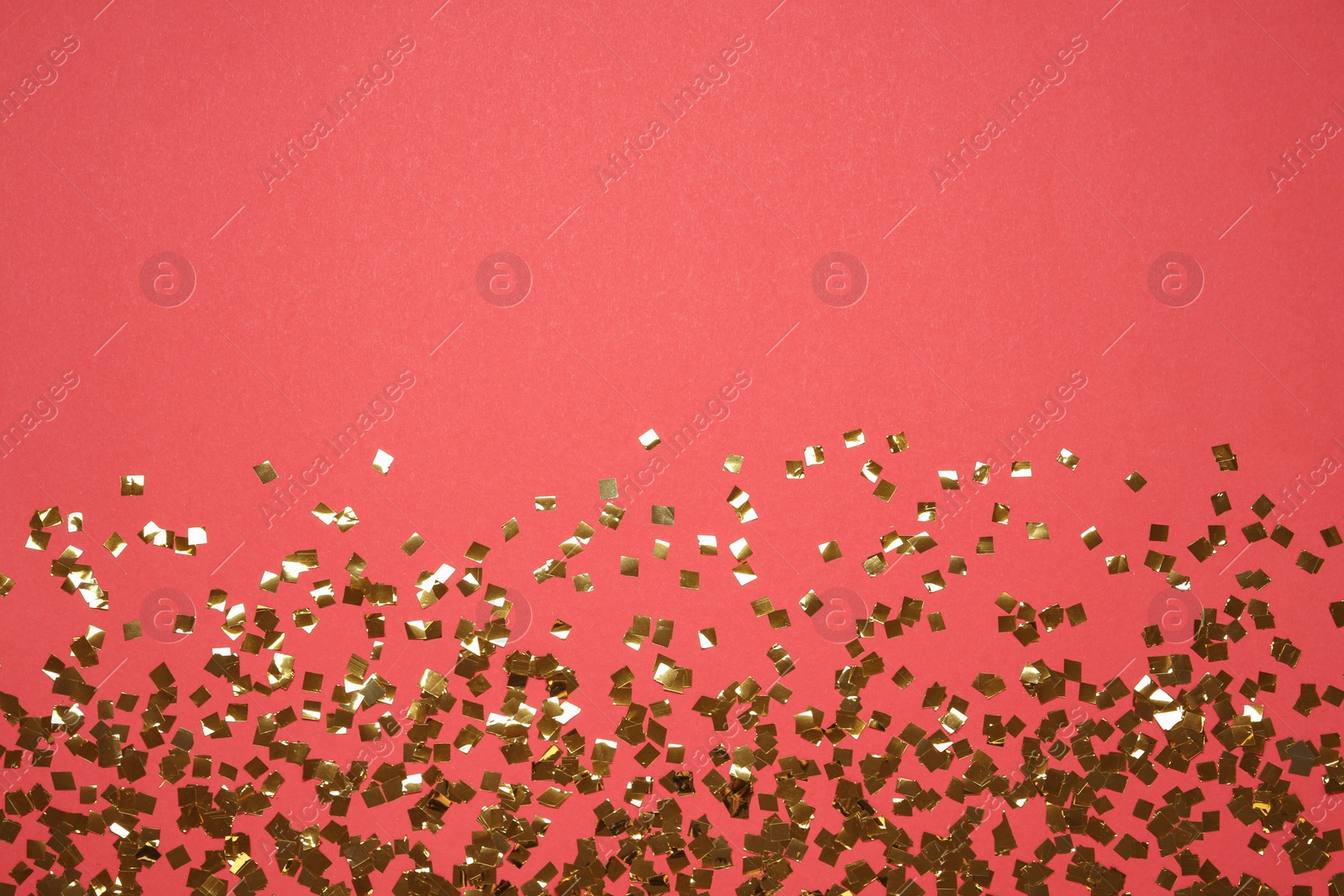 Photo of Shiny golden confetti on red background, flat lay. Space for text