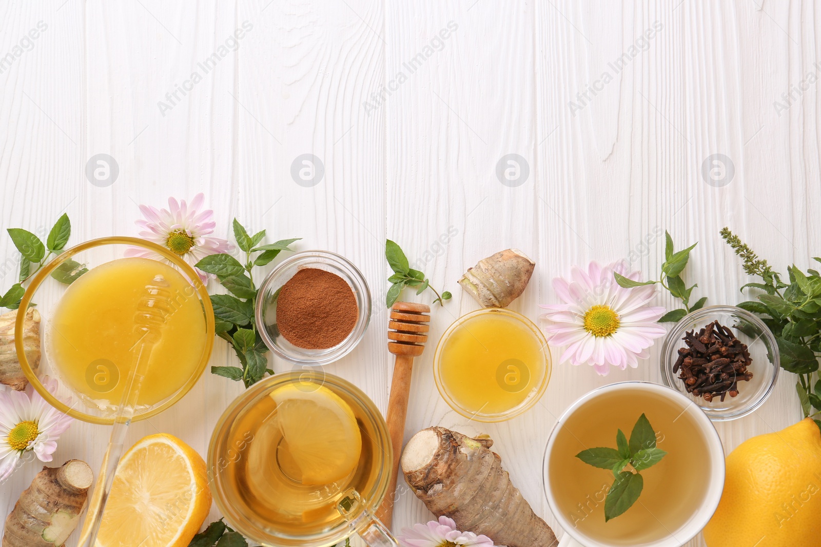 Photo of Flat lay composition with cup of delicious tea, honey and ginger on white wooden table. Space for text