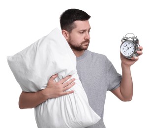 Photo of Unhappy man with pillow and alarm clock on white background. Insomnia problem