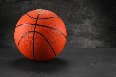 Photo of Basketball ball on dark gray background, space for text