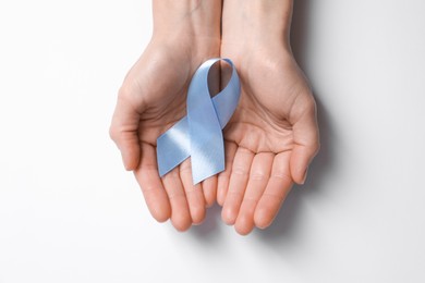 International Psoriasis Day. Woman with light blue ribbon as symbol of support on white background, top view