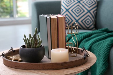 Stylish tray with different interior elements on wooden table in room