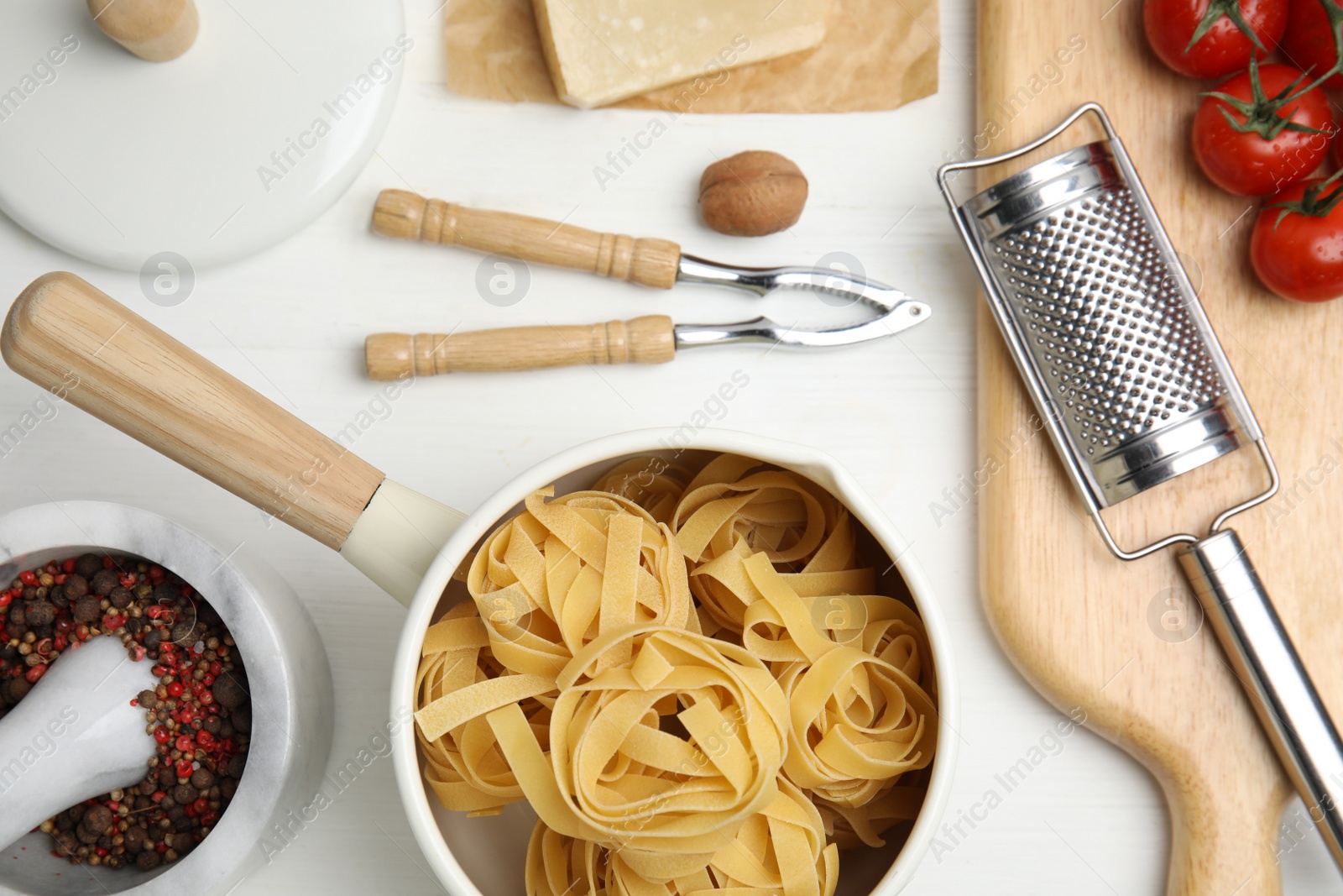 Photo of Cooking utensils and ingredients on white wooden table, flat lay