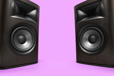 Photo of Wooden sound speakers on violet background. Space for text