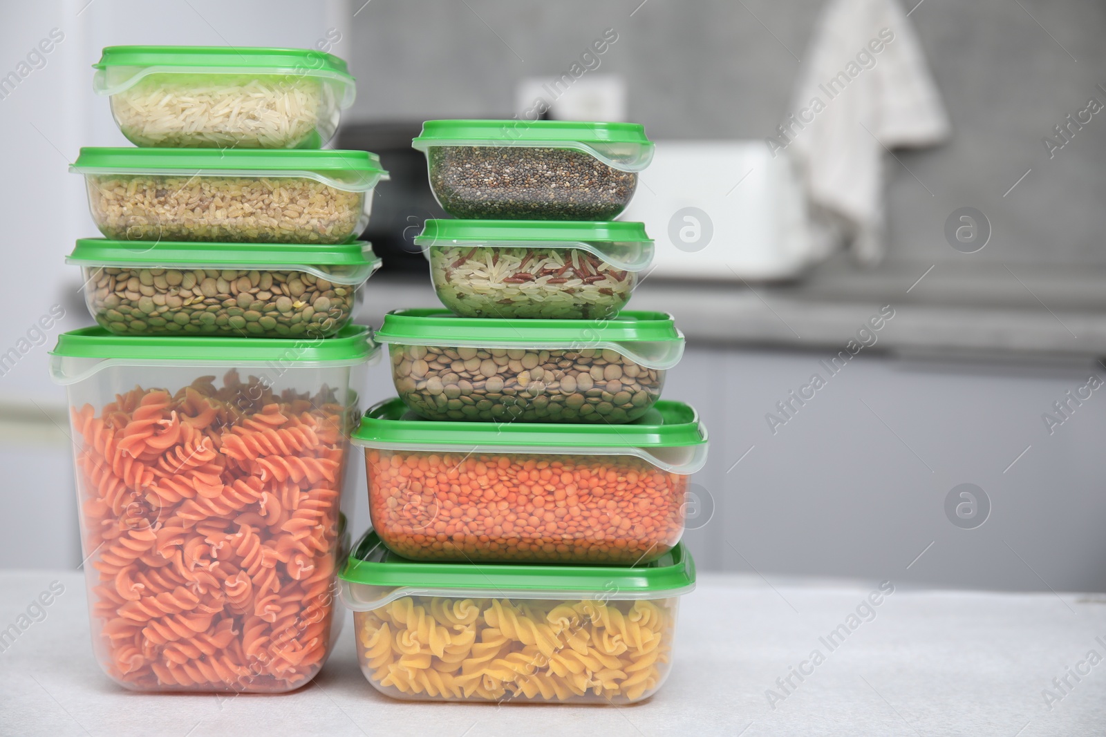 Photo of Plastic containers filled with food products on light table indoors, space for text