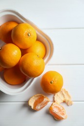 Paper box with fresh ripe tangerines on white wooden table, flat lay