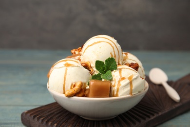 Photo of Delicious ice cream with caramel, popcorn and sauce served on table