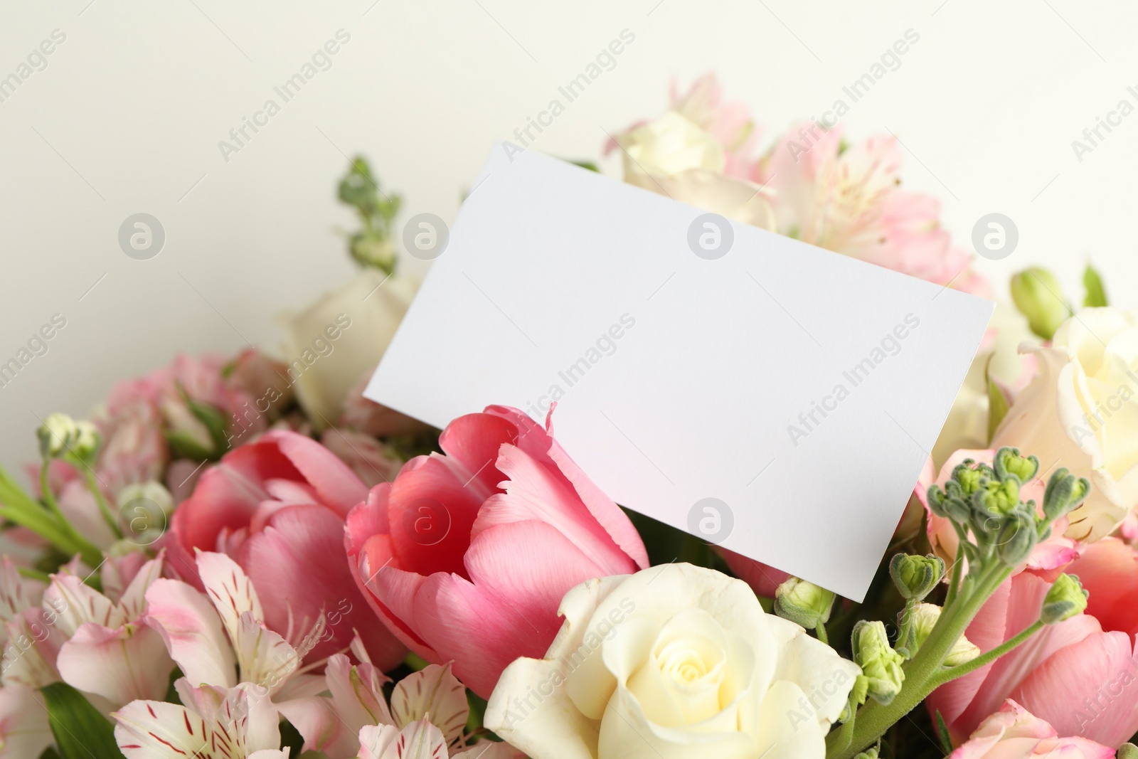 Photo of Happy Mother's Day. Beautiful flowers with blank card on light background, closeup