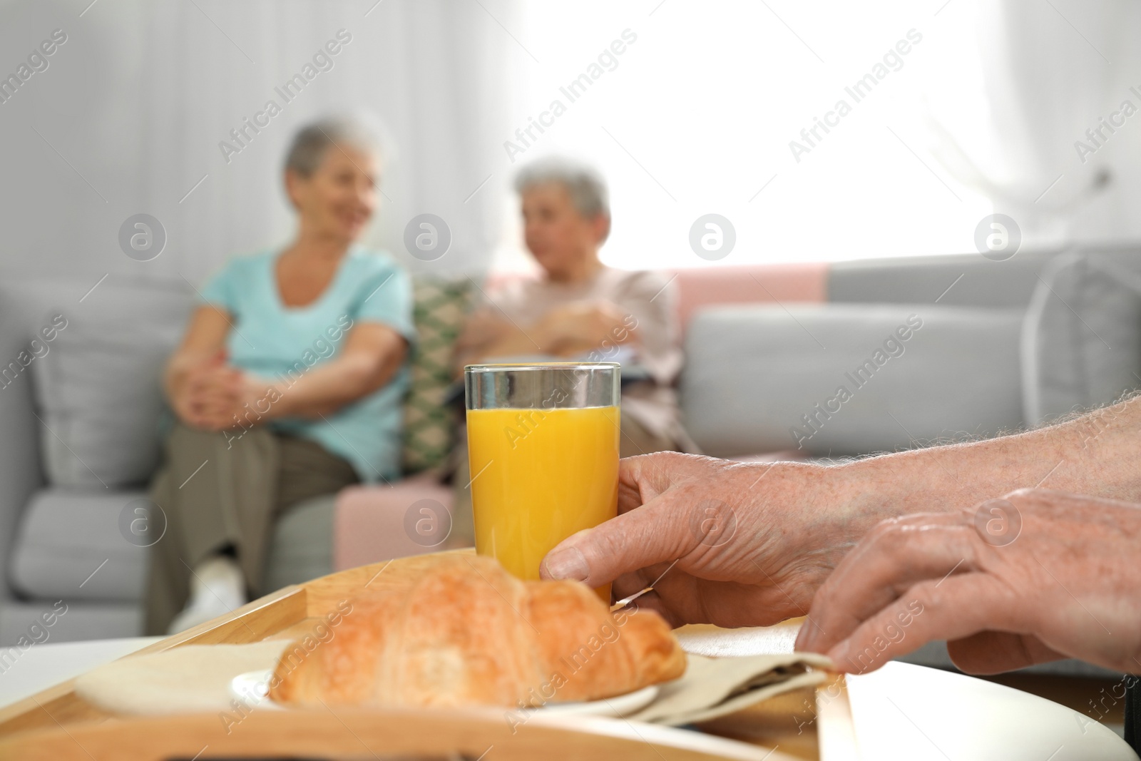 Photo of Elderly man having breakfast at nursing home, closeup with space for text. Assisting senior people