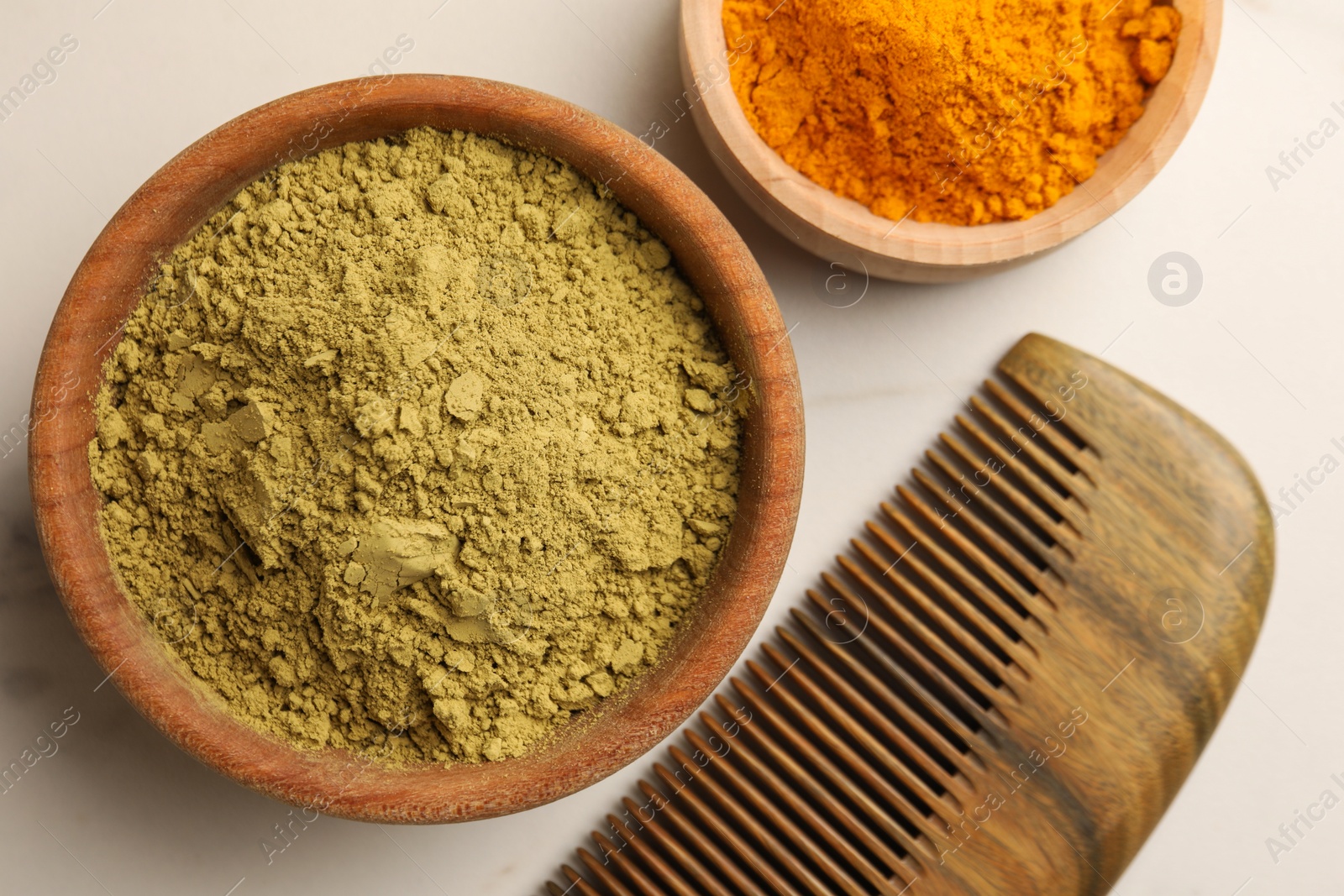 Photo of Comb, henna and turmeric powder on white marble table, flat lay