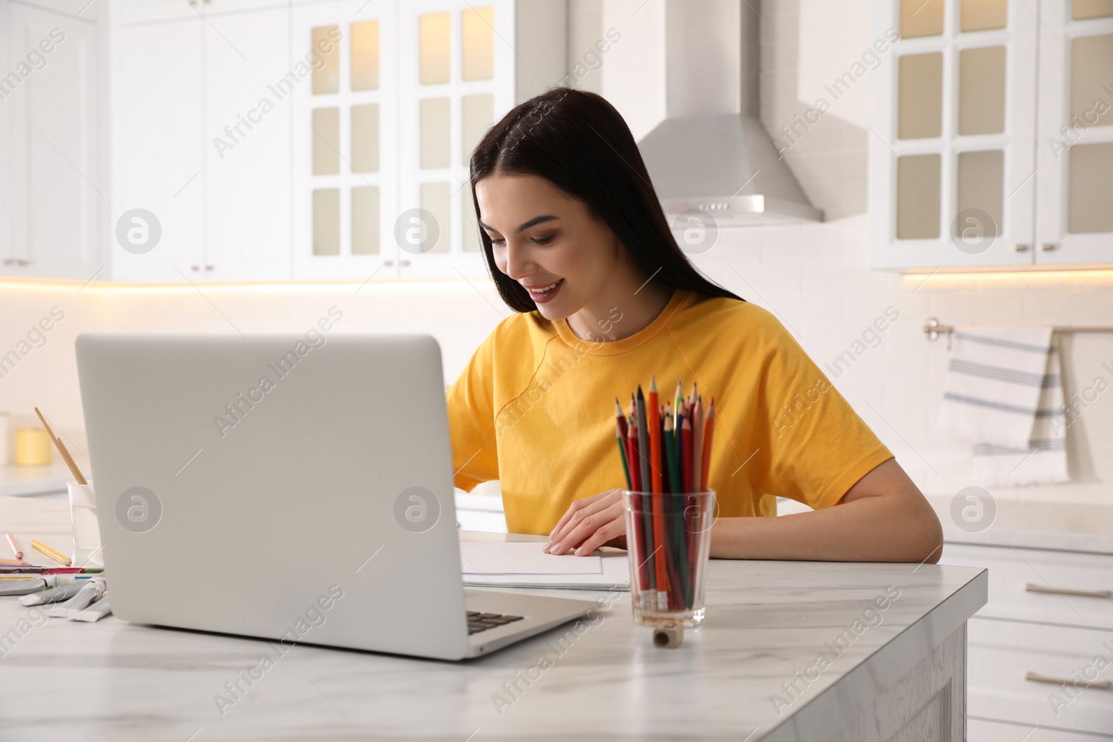 Photo of Happy woman drawing picture at online art lesson indoors. Distant learning