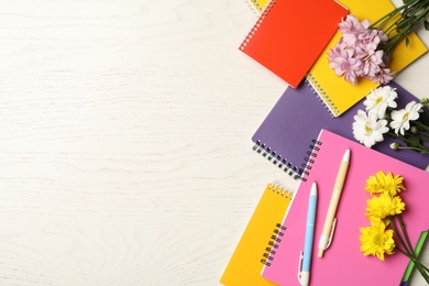 Photo of Set of colorful stationery and flowers on white wooden table, flat lay with space for text. Teacher's Day