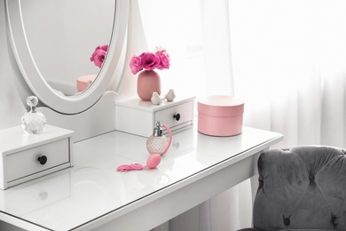 Photo of White dressing table near window in light room