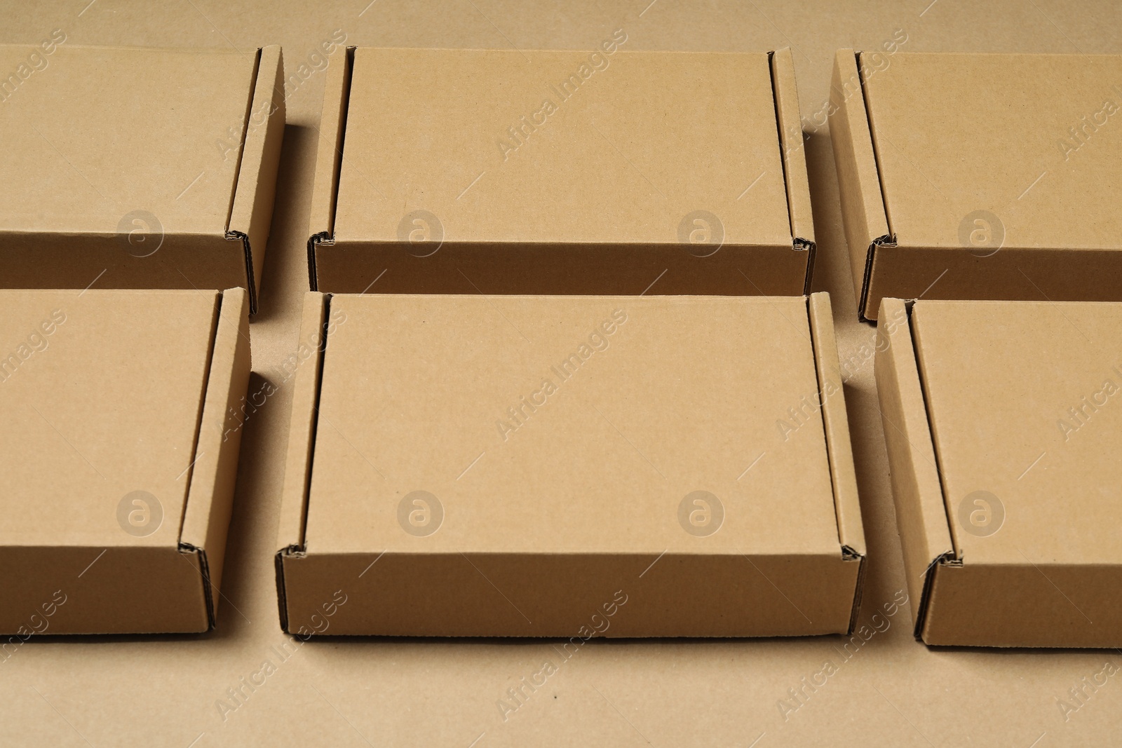 Photo of Many closed cardboard boxes on light brown background