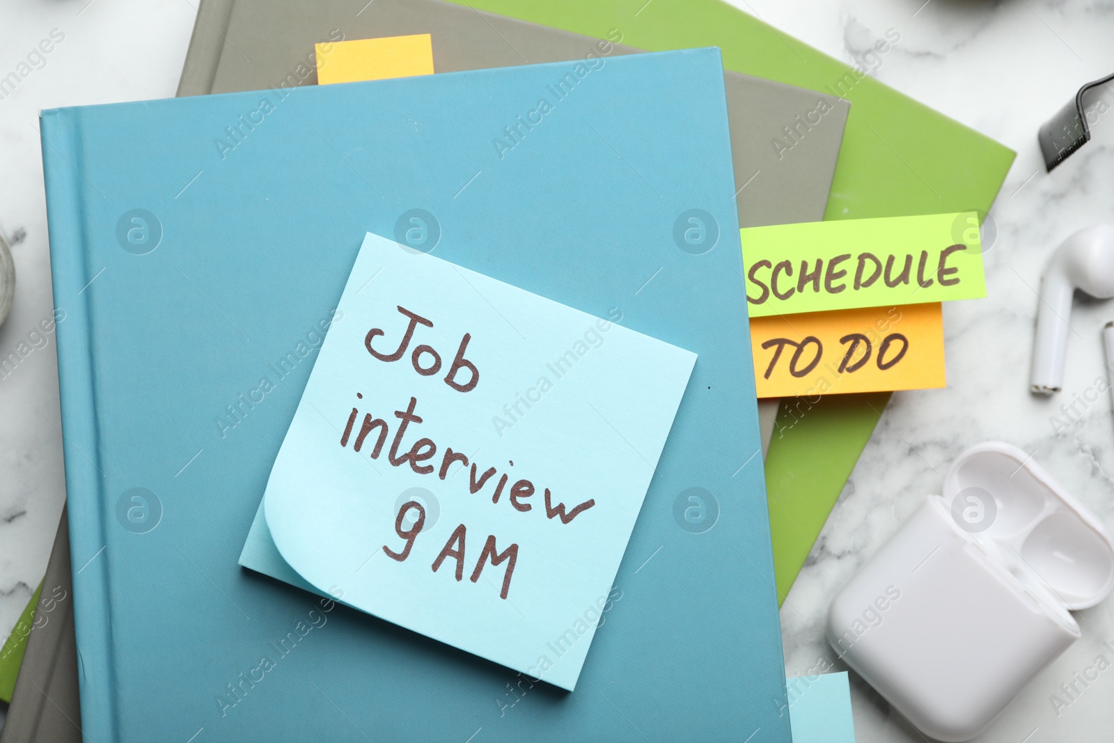 Photo of Reminder note about job interview and stationery on table, flat lay