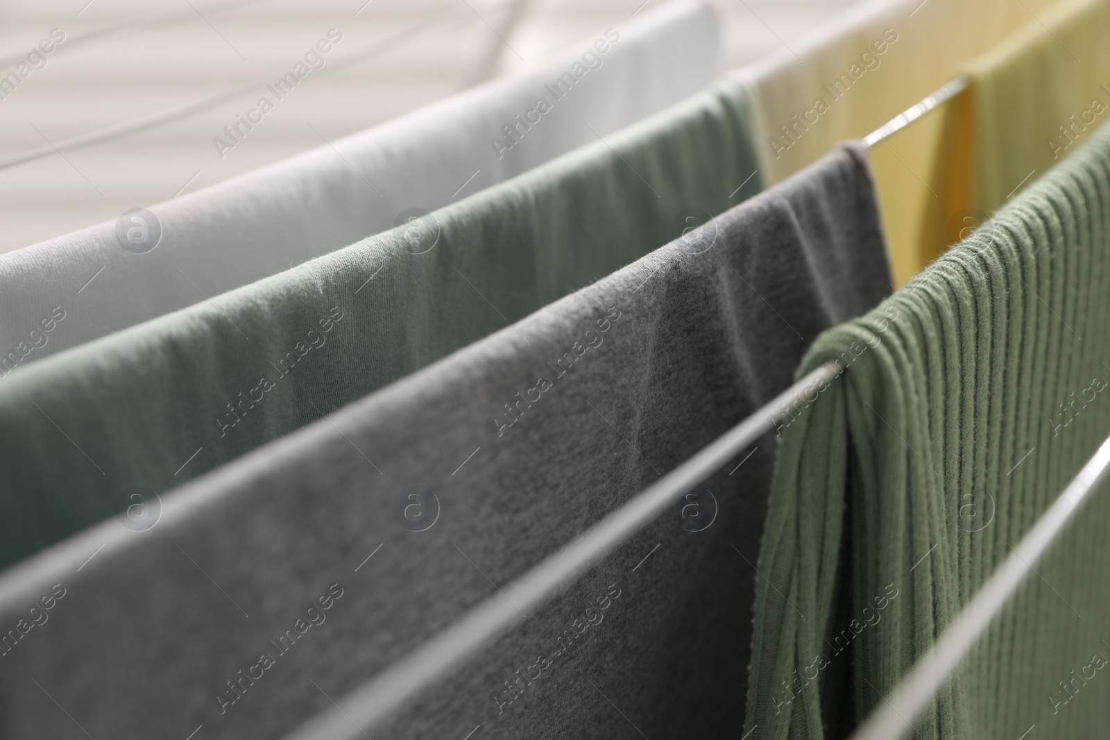 Photo of Different apparel drying on clothes airer, closeup