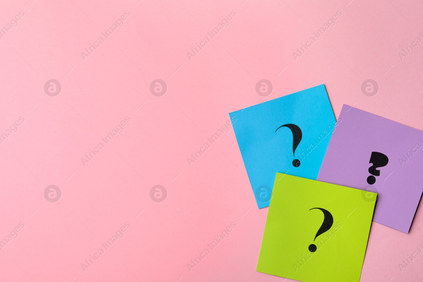 Photo of Paper cards with question marks on pink background, flat lay. Space for text