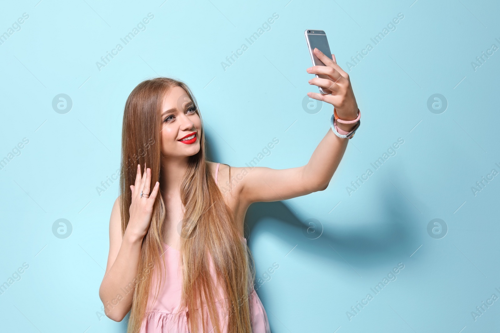 Photo of Attractive young woman taking selfie on color background