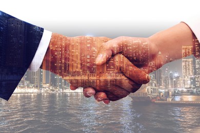 Image of Double exposure of partners shaking hands and cityscape