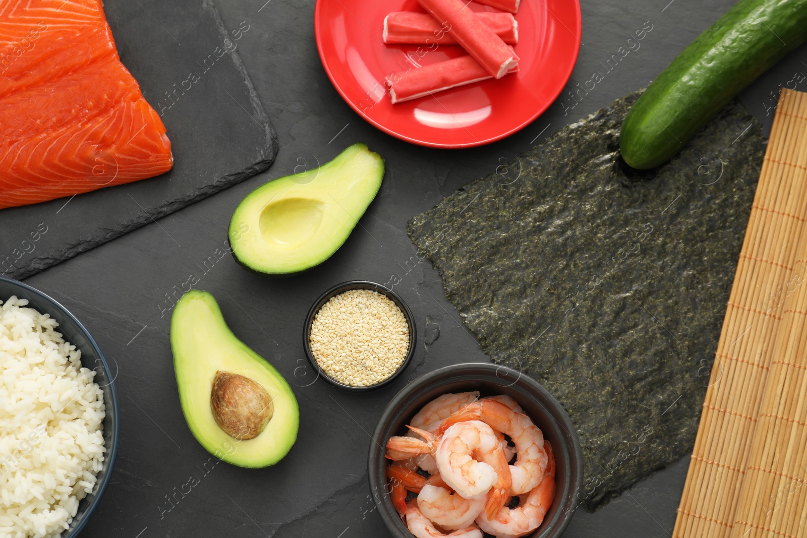 Photo of Flat lay composition with ingredients for sushi on dark textured table