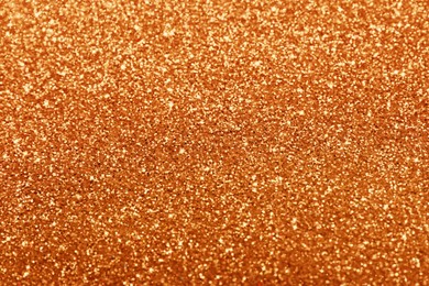 Beautiful shiny orange glitter as background, closeup