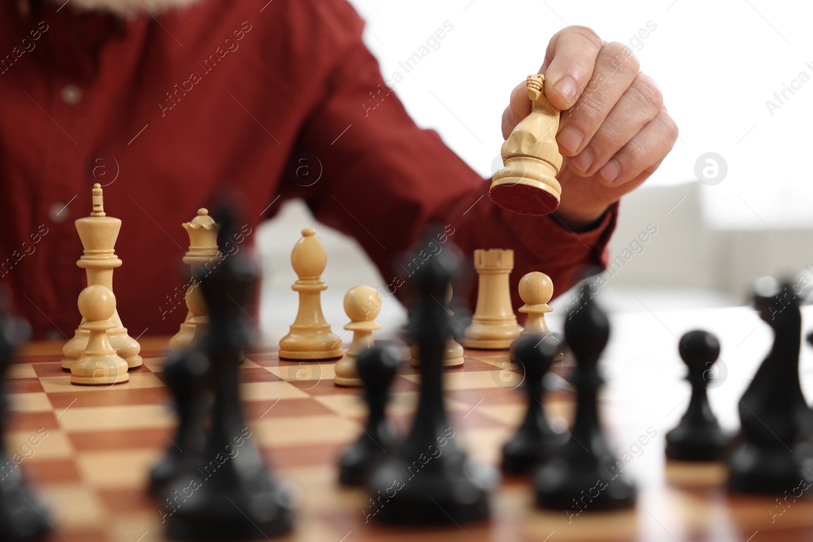 Photo of Man playing chess at table indoors, closeup