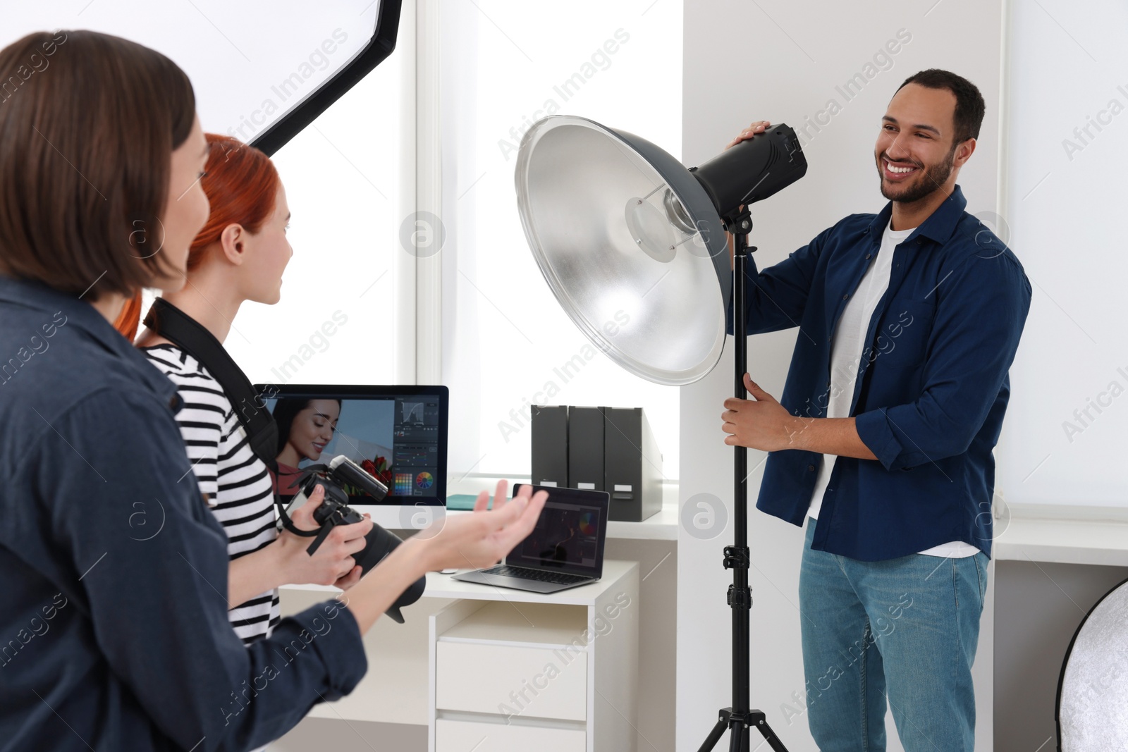 Photo of Young professional photographers working in modern photo studio