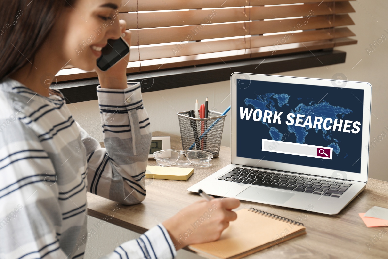 Image of Young woman talking on smartphone in office. Work searches