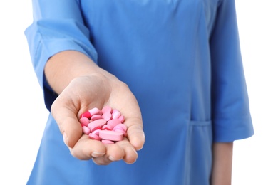 Photo of Female doctor holding pills on white background, closeup. Medical object