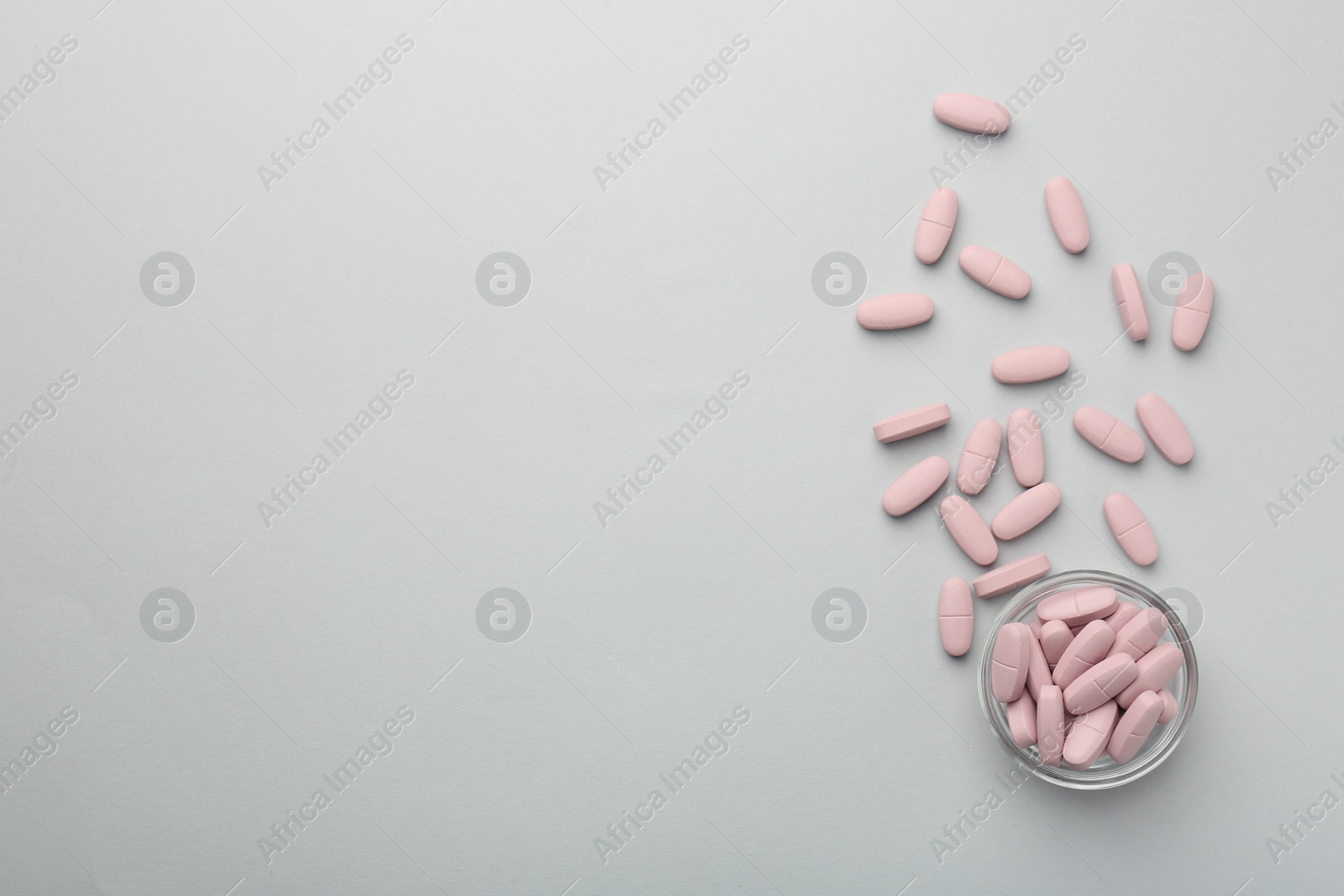 Photo of Vitamin pills on grey background, flat lay. Space for text