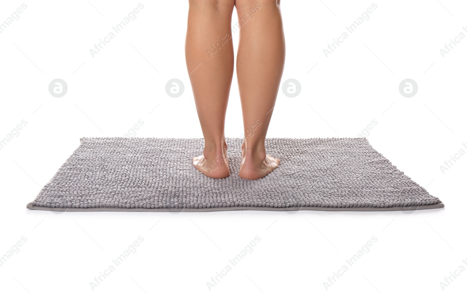 Photo of Woman standing on soft grey bath mat against white background, closeup