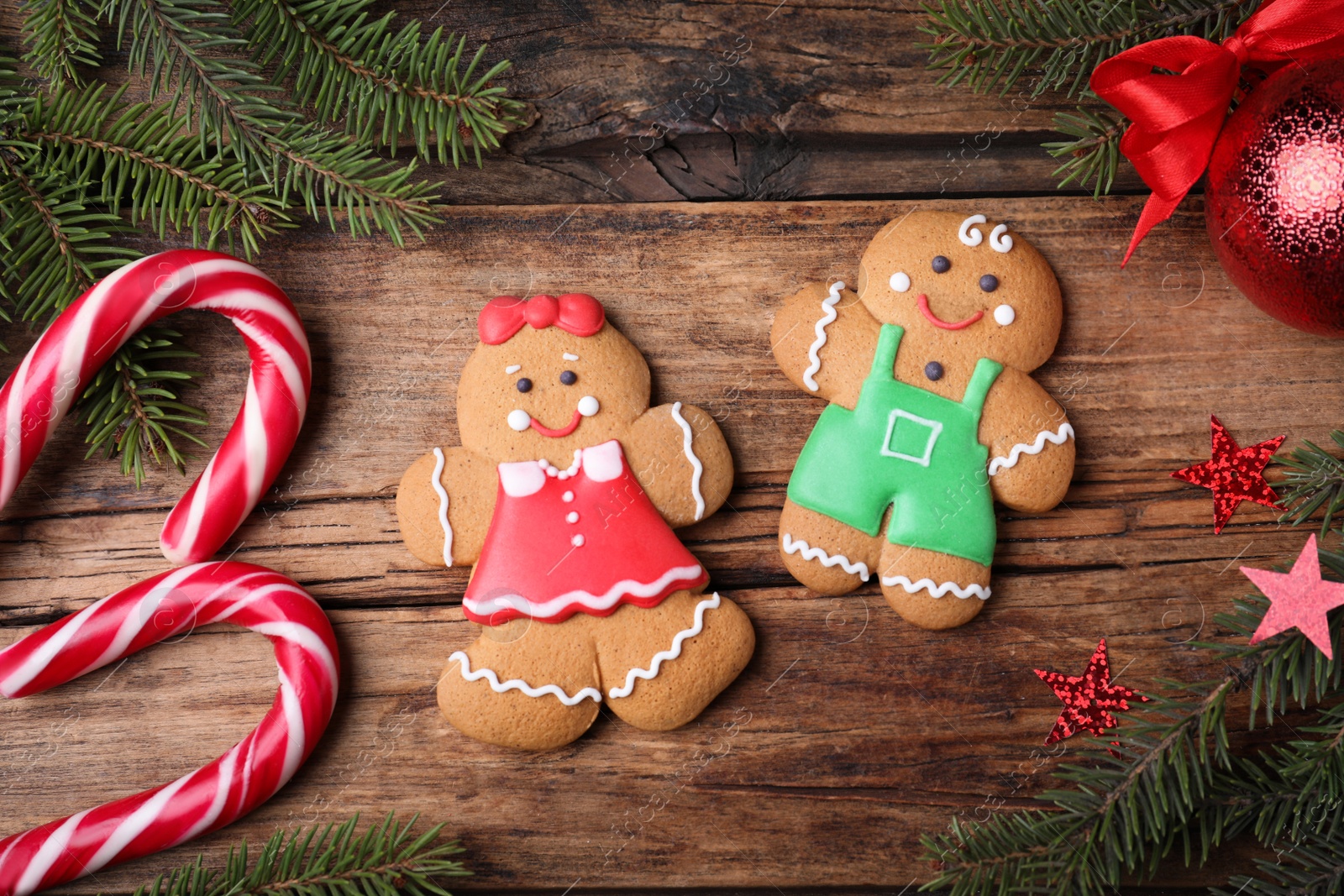 Photo of Flat lay composition with gingerbread couple on wooden table