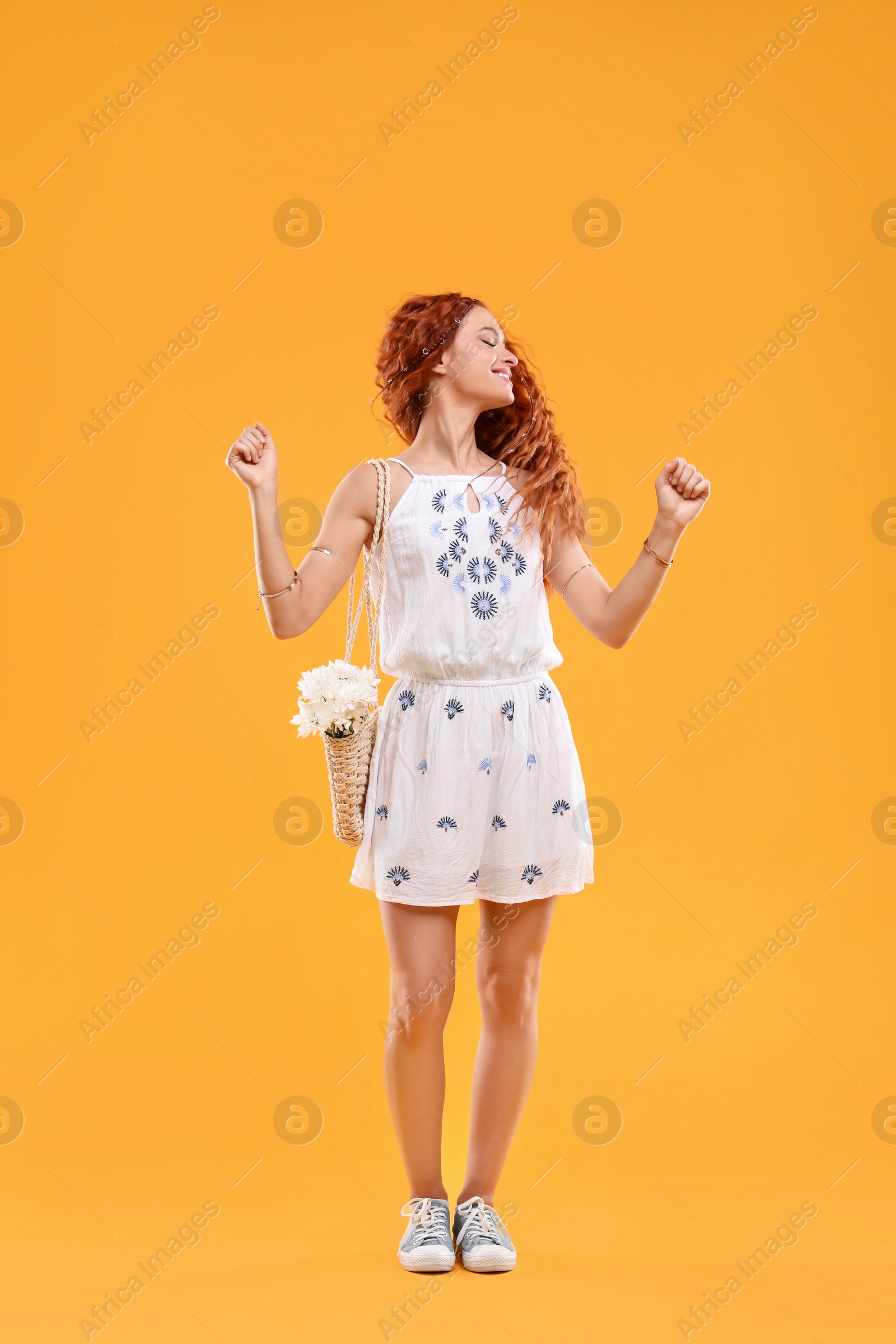 Photo of Beautiful young hippie woman on orange background