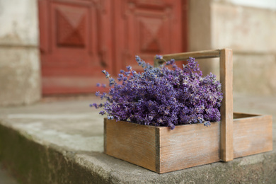 Wooden basket with lavender flowers near building outdoors